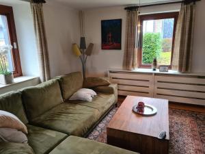 uma sala de estar com um sofá e uma mesa de centro em Haus Päsch nahe See mit beheiztem Whirlpool/Sauna em Bütgenbach