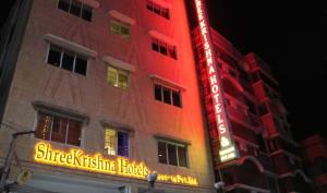 a building with a neon sign on the side of it at SHREE KRISHNA HOTELS & RESORTS PVT LTD in Salua