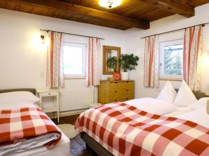 two beds in a room with two windows at Farmhouse in Hollersbach near KitzSki in Hollersbach im Pinzgau