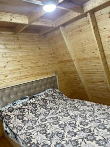 a bedroom with a bed in a room with wooden walls at A.frame.ev.naxcivan in Naxçıvan