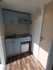 a small kitchen with blue cabinets and a sink at Hillbilly cabin, 2 studios in nature with terrace and parking in Skiathos