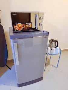 a small refrigerator with a pizza on top of it at Cloud9 Studio Tiara Desaru in Desaru