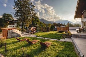 a yard with two benches and a playground at Beautiful cosy House near Königsee in Schönau am Königssee