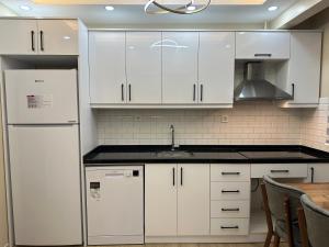 - une cuisine blanche avec des placards blancs et un évier dans l'établissement Centrally Located Family House OldCity, à Istanbul