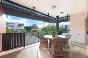 a balcony with a table and chairs and a view at Artistic City Escape with Balcony and Parking in Darwin