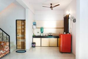 a kitchen with a red refrigerator in a room at THE PERFECT STAYS: MOUNTAIN MANOR VILLA in Lonavala