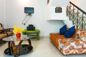 a living room with a couch and a table at THE PERFECT STAYS: MOUNTAIN MANOR VILLA in Lonavala