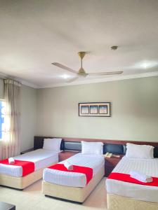 a bedroom with two beds and a ceiling fan at Bayu View Hotel Klang in Klang
