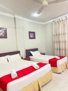 a bedroom with two beds with red and white sheets at Bayu View Hotel Klang in Klang