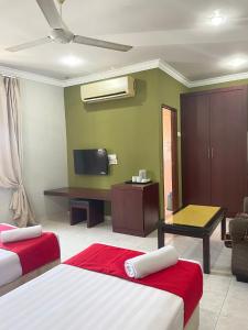 a hotel room with two beds and a flat screen tv at Bayu View Hotel Klang in Klang