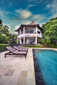 a house with a swimming pool in front of a house at Sing Sing Resort Lovina in Lovina