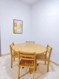a wooden table with two chairs and a table and a wall at AJ HOME - Fahrenheit 88 Pavillion bukit bintang in Kuala Lumpur