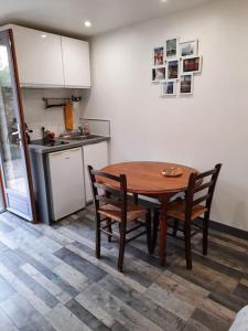 a kitchen with a wooden table and chairs in a kitchen at O MONT D OR in Saint-Romain-au-Mont-dʼOr