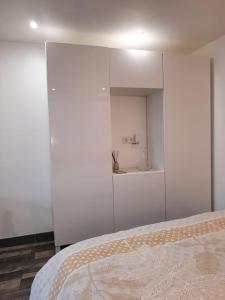 a bedroom with a bed and a white cabinet at O MONT D OR in Saint-Romain-au-Mont-dʼOr