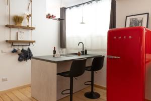 cocina con fregadero y nevera roja en Appartamento Loft Sandy, en Milán