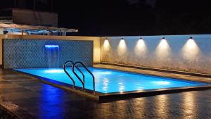 a swimming pool at night with blue lights at Kamal 2 Bedroom Bungalow With Terrace in Kīhīm