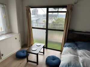 ein Schlafzimmer mit einem Bett und einem Tisch und einem Fenster in der Unterkunft North River 601 Peace Wing 6A in Kami-nagarekawachō