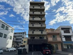 ein hohes Gebäude mit davor geparkt in der Unterkunft North River 601 Peace Wing 6A in Kami-nagarekawachō
