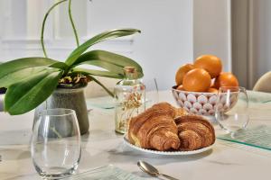 a table with a plate of bread and a bowl of oranges at Le cocon boulevard Yves farge in Lyon