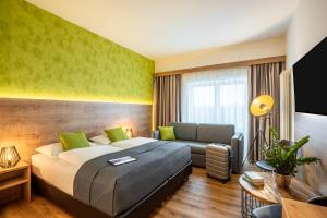 バート・エーンハウゼンにあるMercure Hotel Bad Oeynhausen Cityのベッドとソファのある寝室