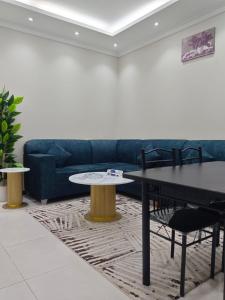 a living room with a couch and two tables at فندق منازل الضيف in Al Madinah