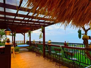 een patio met stoelen en uitzicht op de oceaan bij Sing Sing Resort Lovina in Lovina