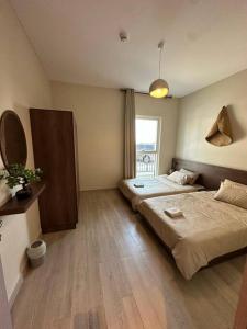 1 dormitorio con 2 camas y ventana grande en 2 bedroom apartment Wabi Sabi in Yas en Abu Dabi