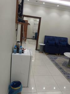 a living room with a table and a blue couch at فندق منازل الضيف in Al Madinah