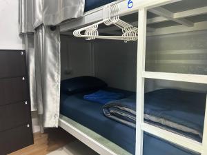 a bunk bed with blue sheets and a ladder at Sweed Dee Seaview Hostel in Phi Phi Islands
