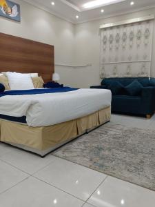 a bedroom with a large bed and a couch at فندق منازل الضيف in Al Madinah