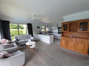 a living room with a couch and a kitchen at Kerikeri Central House in Kerikeri