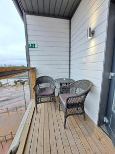dos sillas de mimbre y una mesa en un porche en Starvillas B302, en Kalajoki