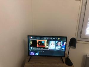 a flat screen tv sitting on a stand in a room at Le cocon boulevard Yves farge in Lyon