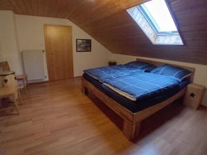 a bedroom with a large blue bed in a attic at Musik und Natur - Balboo - Bayrischer Wald - Sauna - Pool - Grillen in Spiegelau