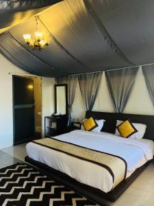 a bedroom with a large bed with yellow pillows at THE CANVAS LONAVLA in Lonavala