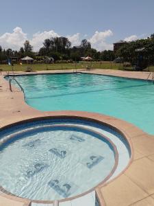a large swimming pool with blue water at Dylan Executive 1 Bedroom Apartment in Nakuru