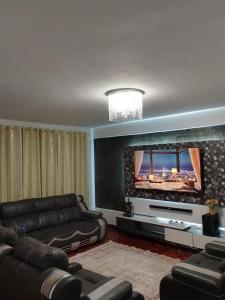 a living room with a couch and a flat screen tv at Dylan Executive 1 Bedroom Apartment in Nakuru