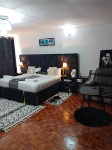 a bedroom with a large bed and a couch at Dylan Executive 1 Bedroom Apartment in Nakuru