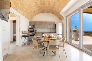 uma cozinha e sala de jantar com mesa e cadeiras em Villa Don Cesare em Marina di Pescoluse