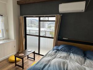 a bedroom with a bed and a large window at North River701 Peace Wing 7 新サッカースタジアム近辺 in Kami-nagarekawachō
