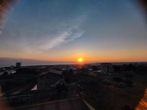 una puesta de sol sobre una ciudad con el sol en el cielo en Dimora EFFE - Eco B&B en Termoli