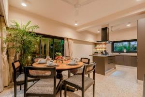 cocina y comedor con mesa de madera y sillas en City chic Luxury villa with Private pool available as 3bhk and 6Bhk en Old Goa