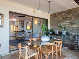une salle à manger avec une table et des chaises en verre dans l'établissement Siesta, à Ballito