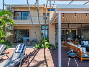 une terrasse avec des chaises et des tables ainsi qu'une maison dans l'établissement Siesta, à Ballito