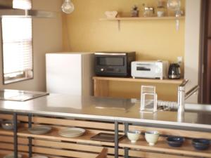 a kitchen with a table with a microwave and a refrigerator at Goto - House - Vacation STAY 66191v in Goto
