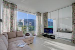 ein Wohnzimmer mit einem Sofa und einem Flachbild-TV in der Unterkunft Darma's House 3 minutes from Monate lake - Happy Rentals in Cadrezzate