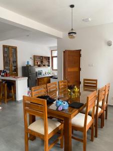 a kitchen and dining room with a wooden table and chairs at THE DOCTORS VILLA in Ragama