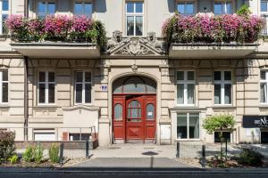 an apartment building with a red door and flowers at Modern Apartment with Balcony 2 km to Poznan International Fair by Renters in Poznań