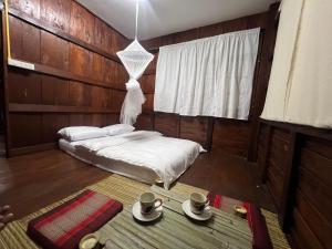 a bedroom with a bed and two cups and a table at Eden Farmstay CNX 