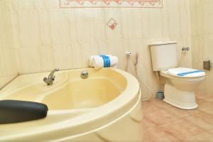 a bathroom with a bath tub and a toilet at Thushine Hotel in Seeduwa